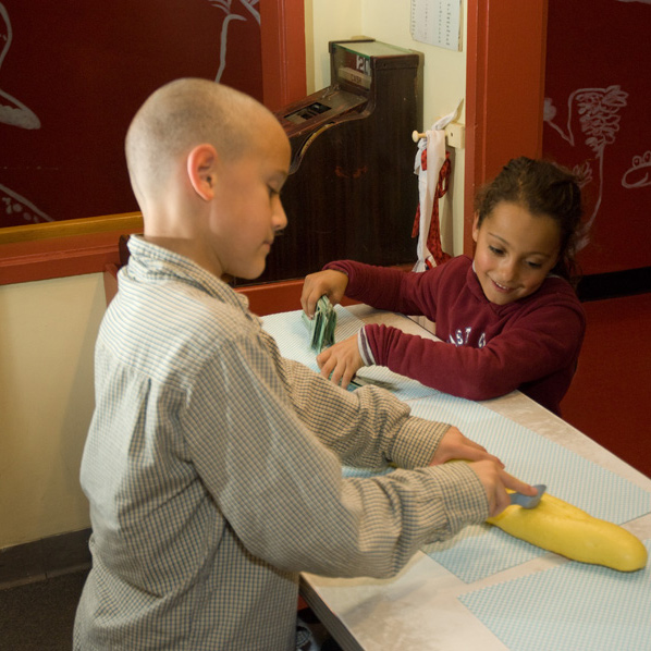 Two children interacting with cooking exhibit