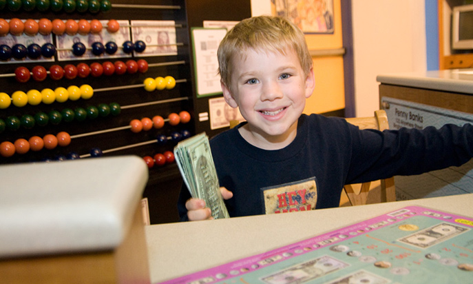 Boy playing at banking exhibit